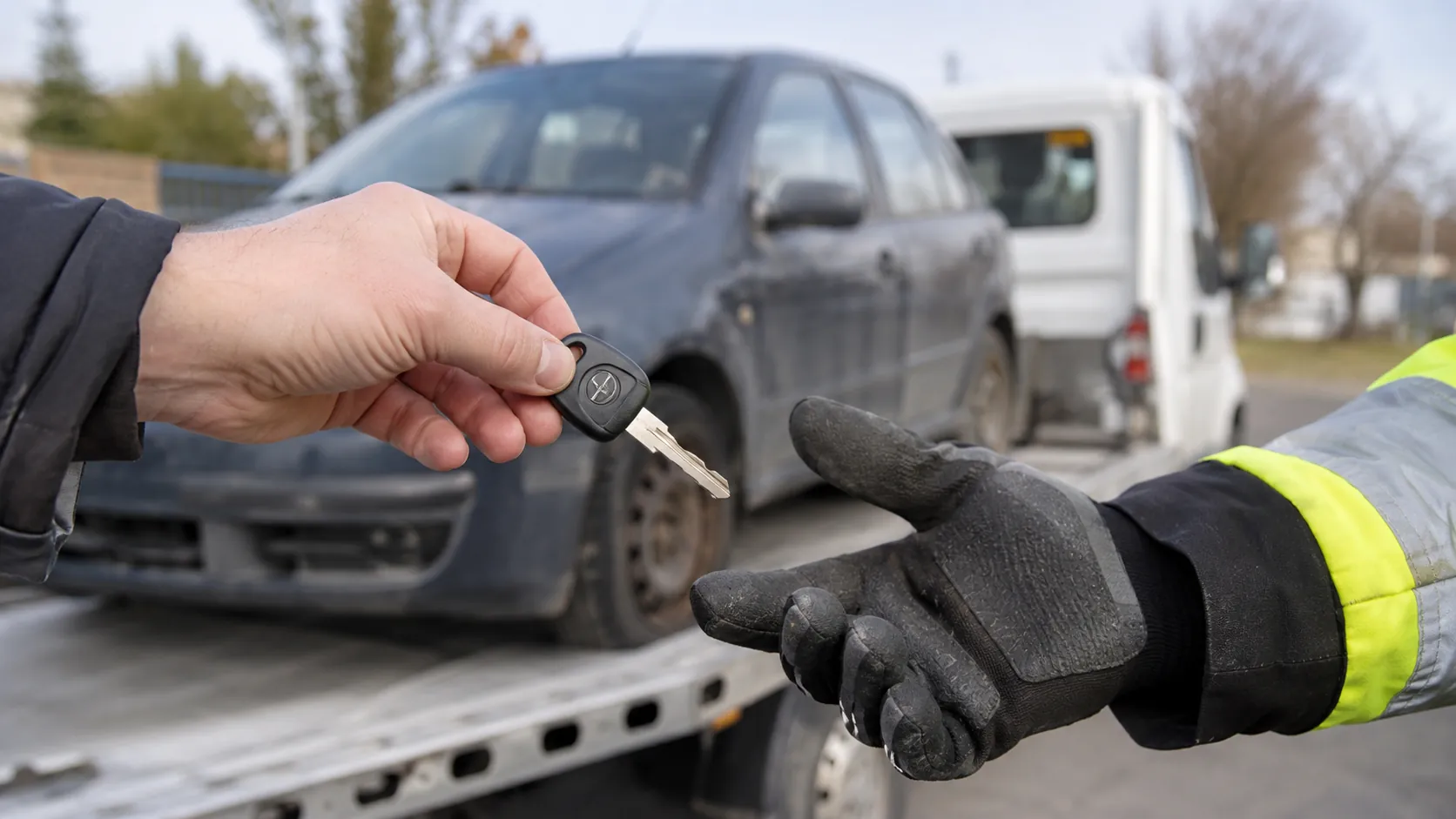 Předání klíčku od vozidla řidiči v pracovní rukavici