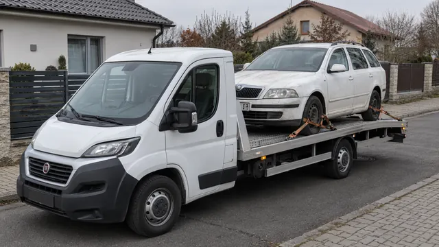 Bílý odtahový vůz s upevněným vozidlem Škoda na hliníkové plošině