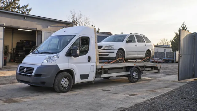 Bílý odtahový vůz s upevněným vozidlem Škoda na hliníkové plošině