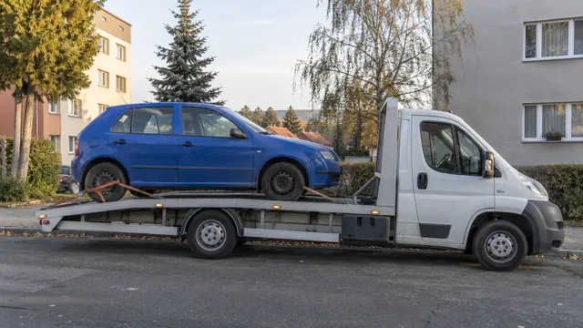 Bílý odtahový vůz s upevněným vozidlem Škoda na hliníkové plošině