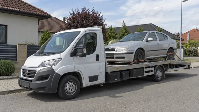 Bílý odtahový vůz s upevněným vozidlem Škoda na hliníkové plošině