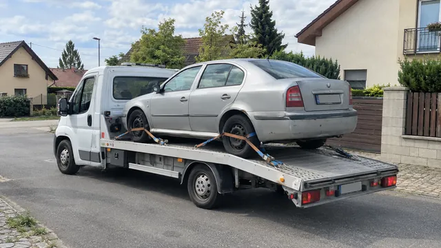 Bílý odtahový vůz s upevněným vozidlem Škoda na hliníkové plošině