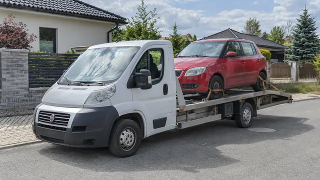 Bílý odtahový vůz s upevněným vozidlem Škoda na hliníkové plošině