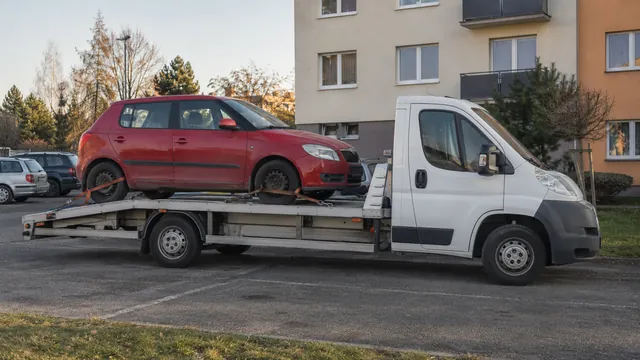 Bílý odtahový vůz s upevněným vozidlem Škoda na hliníkové plošině