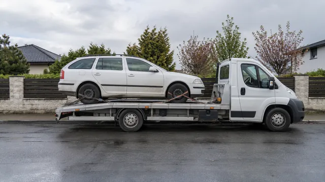 Bílý odtahový vůz s upevněným vozidlem Škoda na hliníkové plošině