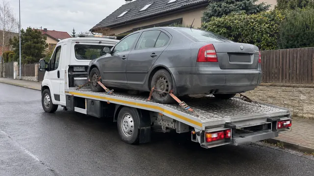 Bílý odtahový vůz s upevněným vozidlem Škoda na hliníkové plošině