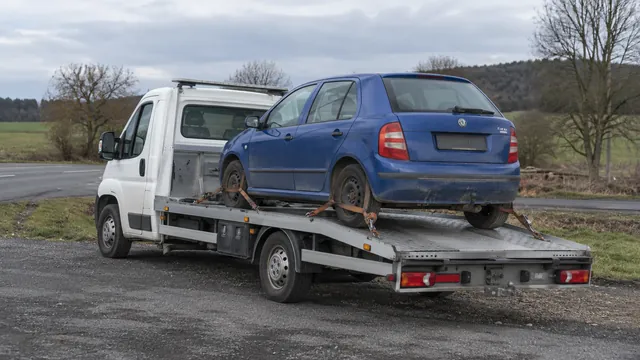 Bílý odtahový vůz s upevněným vozidlem Škoda na hliníkové plošině