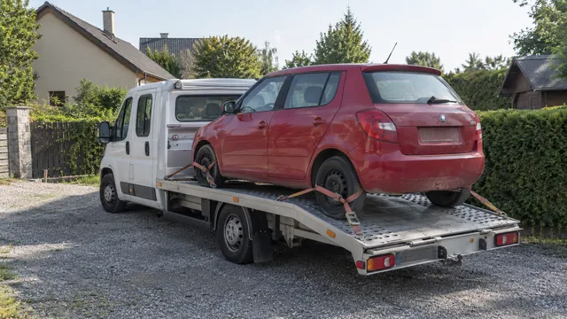 Bílý odtahový vůz s upevněným vozidlem Škoda na hliníkové plošině