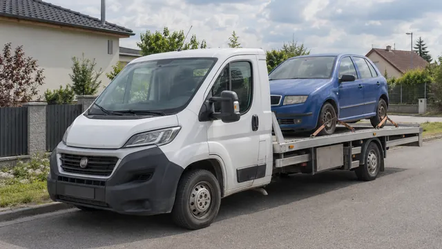 Bílý odtahový vůz s upevněným vozidlem Škoda na hliníkové plošině