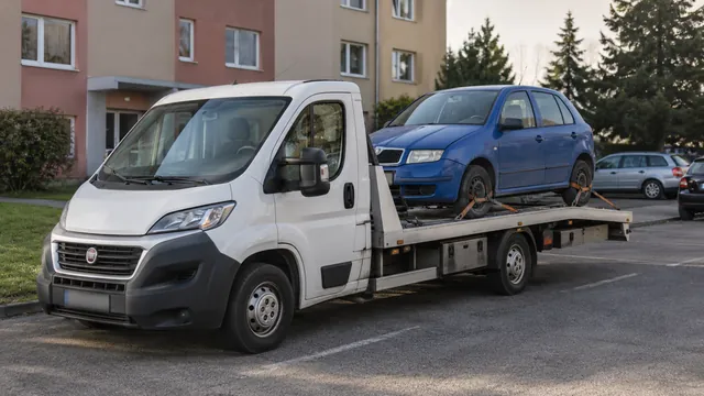 Bílý odtahový vůz s upevněným vozidlem Škoda na hliníkové plošině