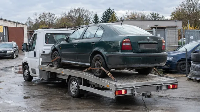 Bílý odtahový vůz s upevněným vozidlem Škoda na hliníkové plošině