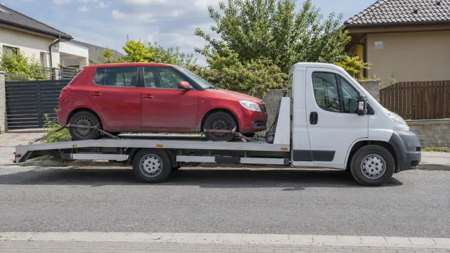 Bílý odtahový vůz s upevněným vozidlem Škoda na hliníkové plošině