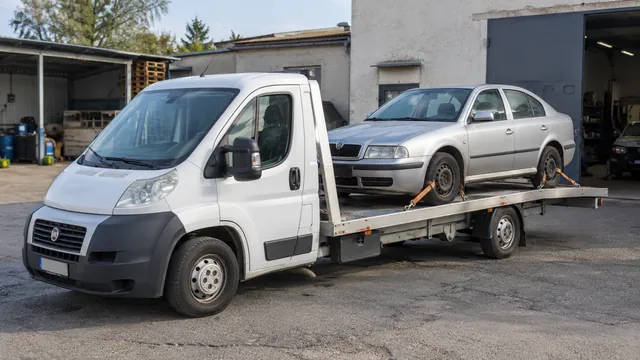 Bílý odtahový vůz s upevněným vozidlem Škoda na hliníkové plošině
