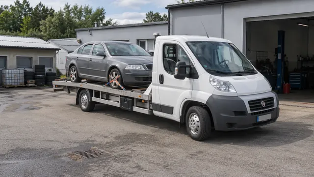 Bílý odtahový vůz s upevněným vozidlem Škoda na hliníkové plošině