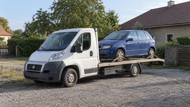 Bílý odtahový vůz s upevněným vozidlem Škoda na hliníkové plošině
