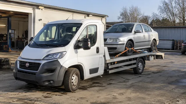 Bílý odtahový vůz s upevněným vozidlem Škoda na hliníkové plošině