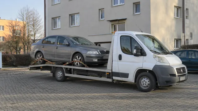 Bílý odtahový vůz s upevněným vozidlem Škoda na hliníkové plošině