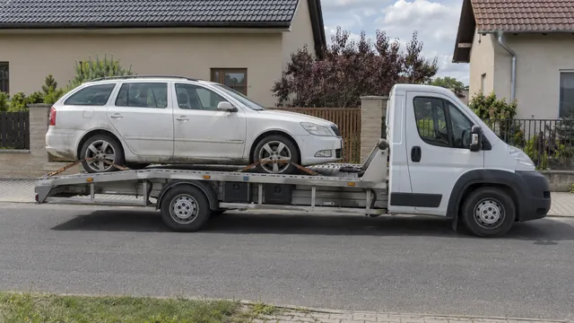 Bílý odtahový vůz s upevněným vozidlem Škoda na hliníkové plošině