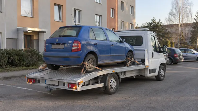 Bílý odtahový vůz s upevněným vozidlem Škoda na hliníkové plošině