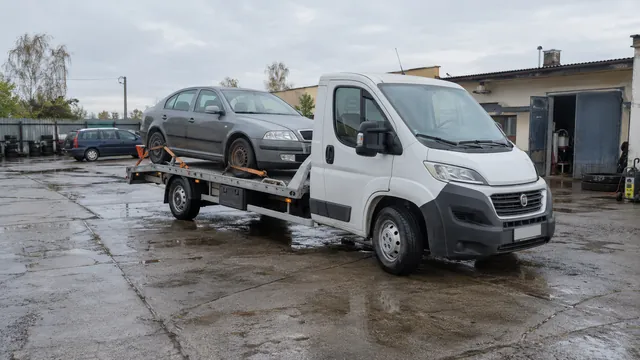 Bílý odtahový vůz s upevněným vozidlem Škoda na hliníkové plošině