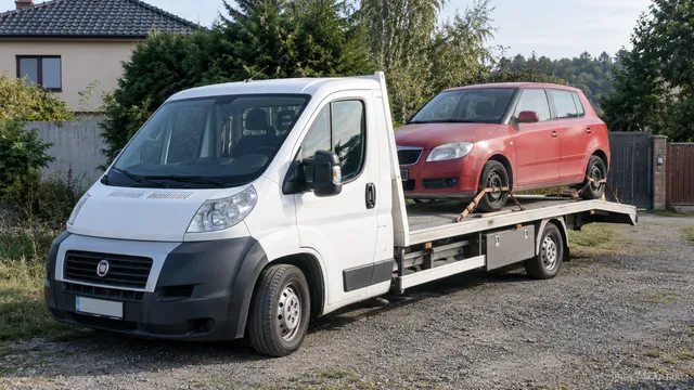 Bílý odtahový vůz s upevněným vozidlem Škoda na hliníkové plošině