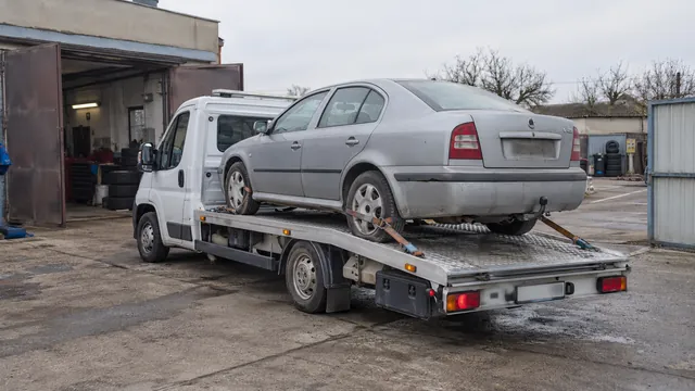 Bílý odtahový vůz s upevněným vozidlem Škoda na hliníkové plošině