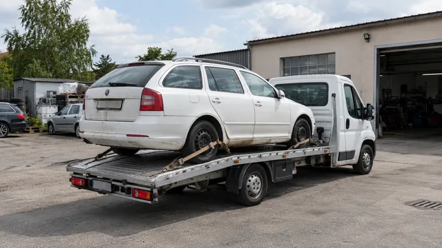 Bílý odtahový vůz s upevněným vozidlem Škoda na hliníkové plošině
