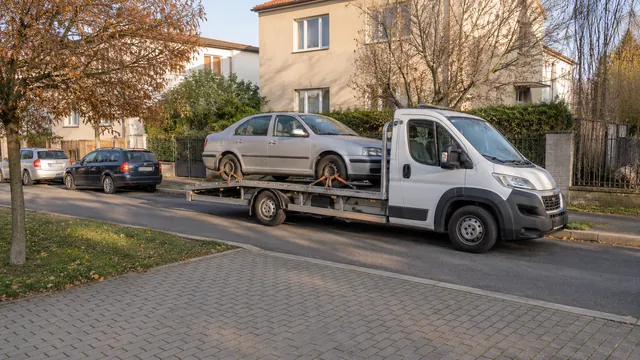 Bílý odtahový vůz s upevněným vozidlem Škoda na hliníkové plošině