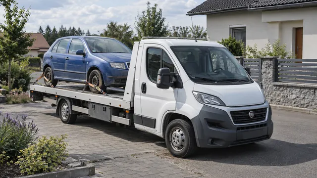 Bílý odtahový vůz s upevněným vozidlem Škoda na hliníkové plošině