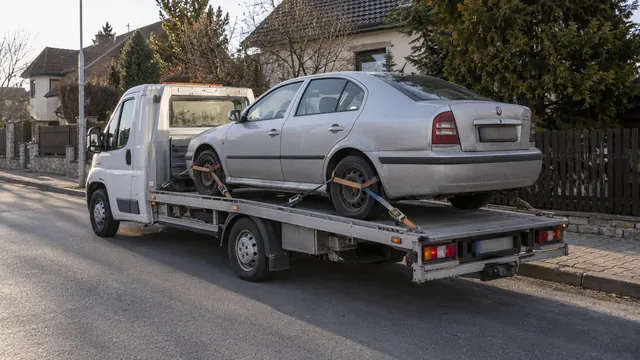 Bílý odtahový vůz s upevněným vozidlem Škoda na hliníkové plošině