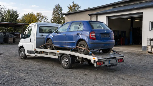 Bílý odtahový vůz s upevněným vozidlem Škoda na hliníkové plošině