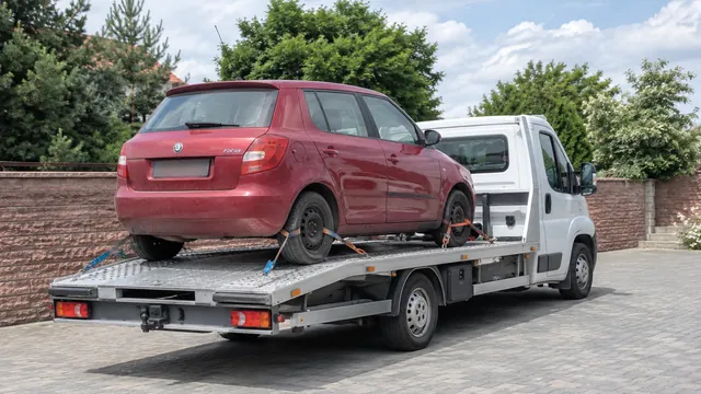 Bílý odtahový vůz s upevněným vozidlem Škoda na hliníkové plošině