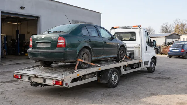 Bílý odtahový vůz s upevněným vozidlem Škoda na hliníkové plošině