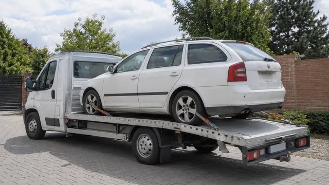 Bílý odtahový vůz s upevněným vozidlem Škoda na hliníkové plošině