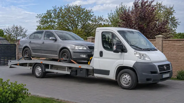 Bílý odtahový vůz s upevněným vozidlem Škoda na hliníkové plošině