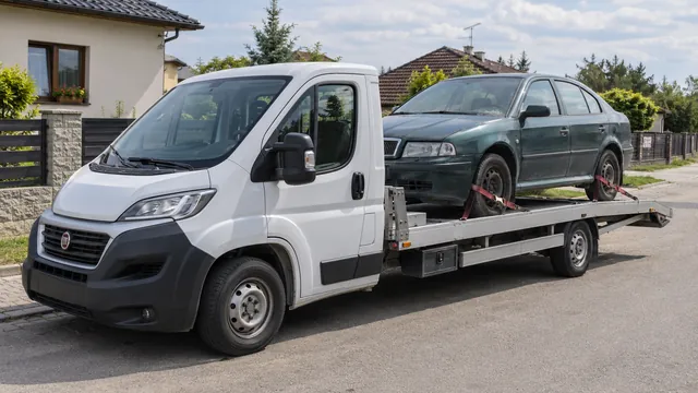 Bílý odtahový vůz s upevněným vozidlem Škoda na hliníkové plošině
