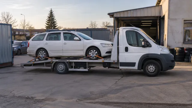 Bílý odtahový vůz s upevněným vozidlem Škoda na hliníkové plošině
