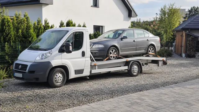 Bílý odtahový vůz s upevněným vozidlem Škoda na hliníkové plošině
