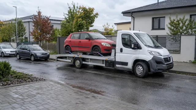 Bílý odtahový vůz s upevněným vozidlem Škoda na hliníkové plošině