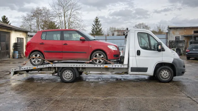 Bílý odtahový vůz s upevněným vozidlem Škoda na hliníkové plošině