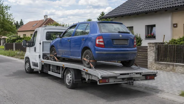 Bílý odtahový vůz s upevněným vozidlem Škoda na hliníkové plošině