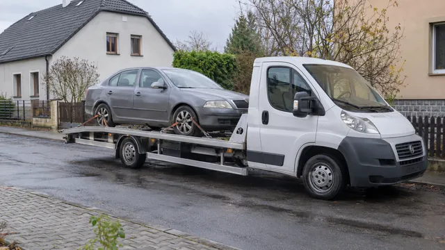 Bílý odtahový vůz s upevněným vozidlem Škoda na hliníkové plošině