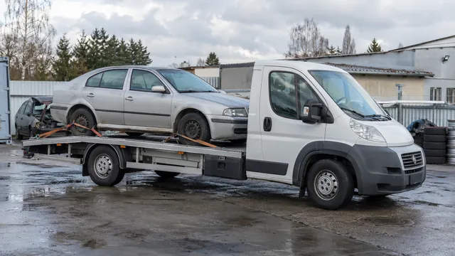 Bílý odtahový vůz s upevněným vozidlem Škoda na hliníkové plošině