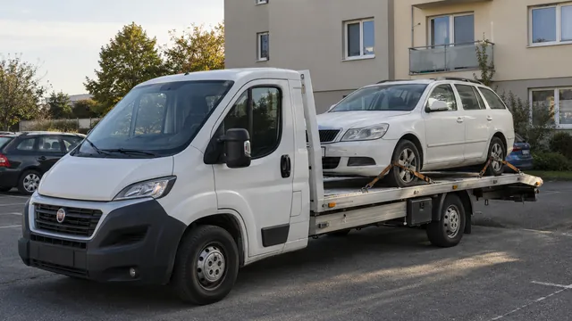 Bílý odtahový vůz s upevněným vozidlem Škoda na hliníkové plošině