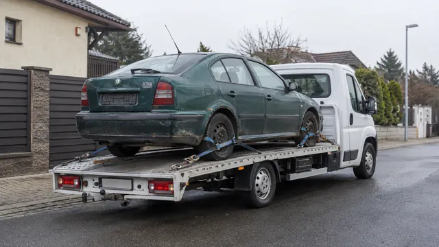 Bílý odtahový vůz s upevněným vozidlem Škoda na hliníkové plošině