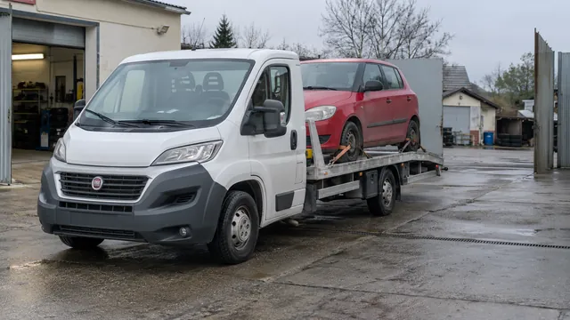 Bílý odtahový vůz s upevněným vozidlem Škoda na hliníkové plošině