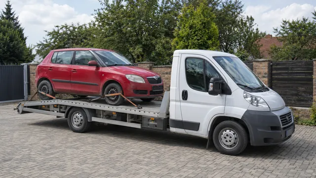 Bílý odtahový vůz s upevněným vozidlem Škoda na hliníkové plošině
