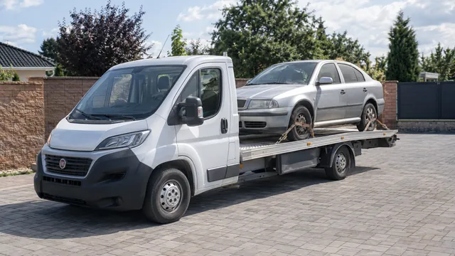 Bílý odtahový vůz s upevněným vozidlem Škoda na hliníkové plošině