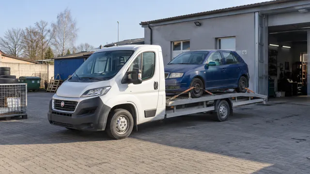 Bílý odtahový vůz s upevněným vozidlem Škoda na hliníkové plošině