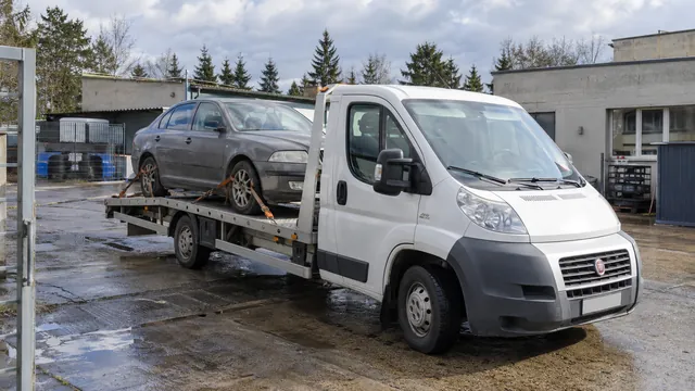 Bílý odtahový vůz s upevněným vozidlem Škoda na hliníkové plošině